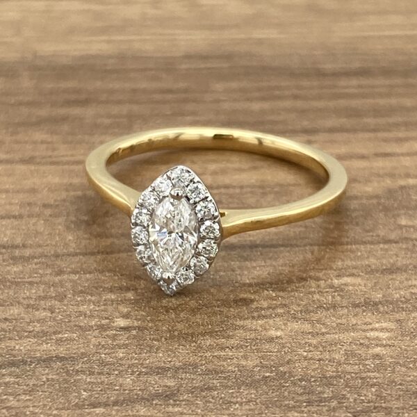 Gold ring with marquise diamond halo setting.