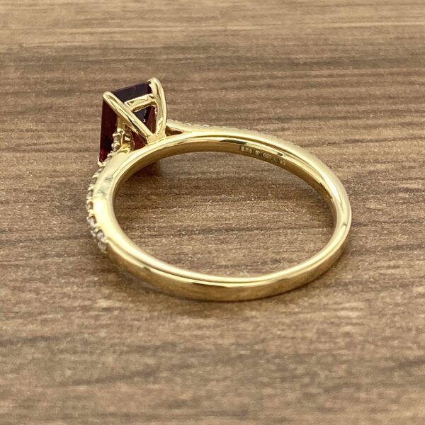 Gold ring with a red gemstone.