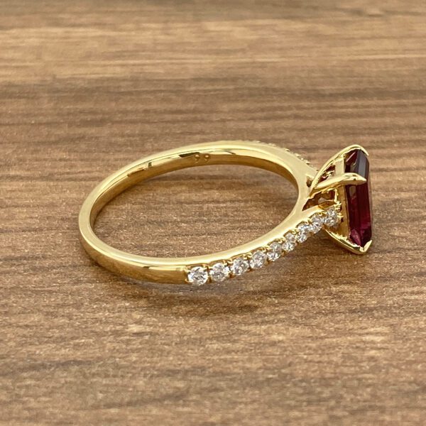 Gold ring with red gemstone and diamonds.