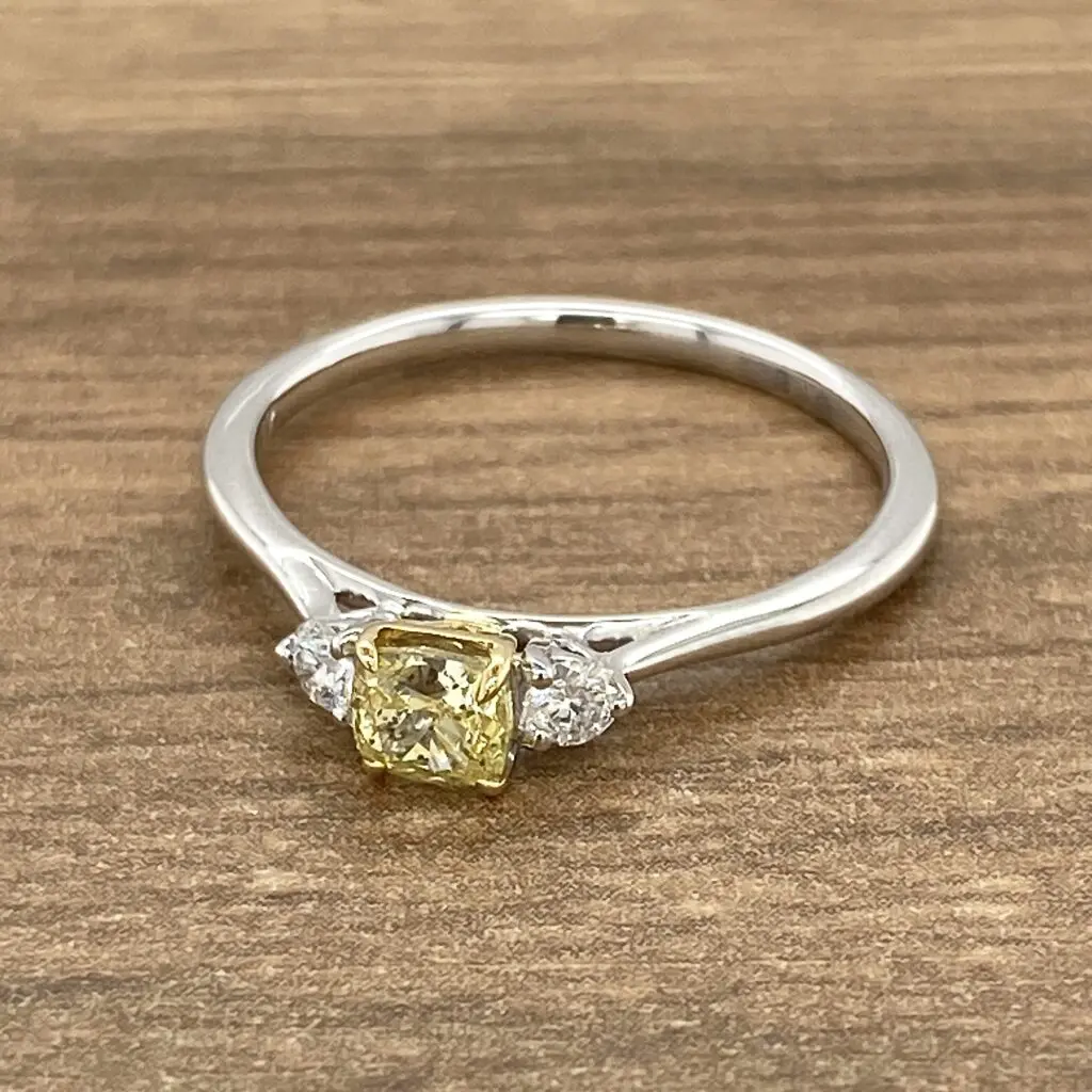 An engagement ring with a yellow diamond and diamonds.