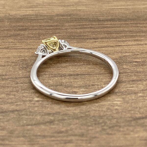 An engagement ring with a yellow and white diamond.