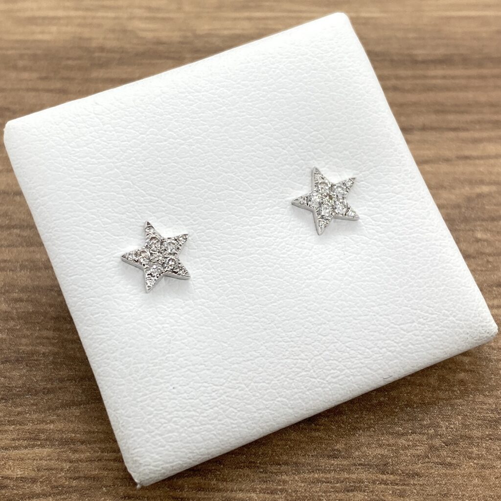 A pair of star stud earrings on a white box.