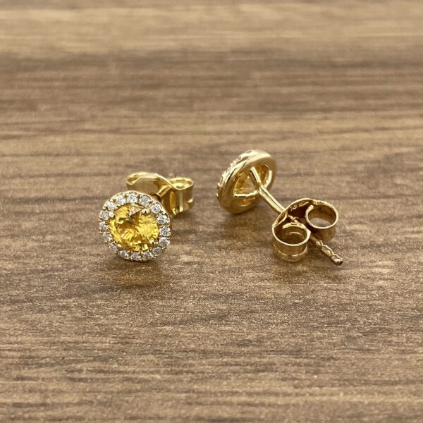 Pair of gold earrings with yellow stones.