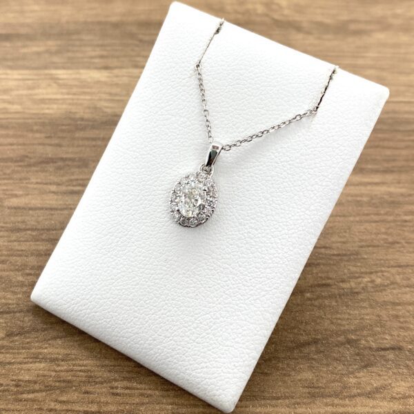 A white gold pendant with a diamond in the center.