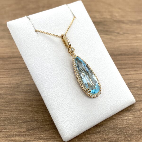 A necklace with a blue topaz and diamonds.