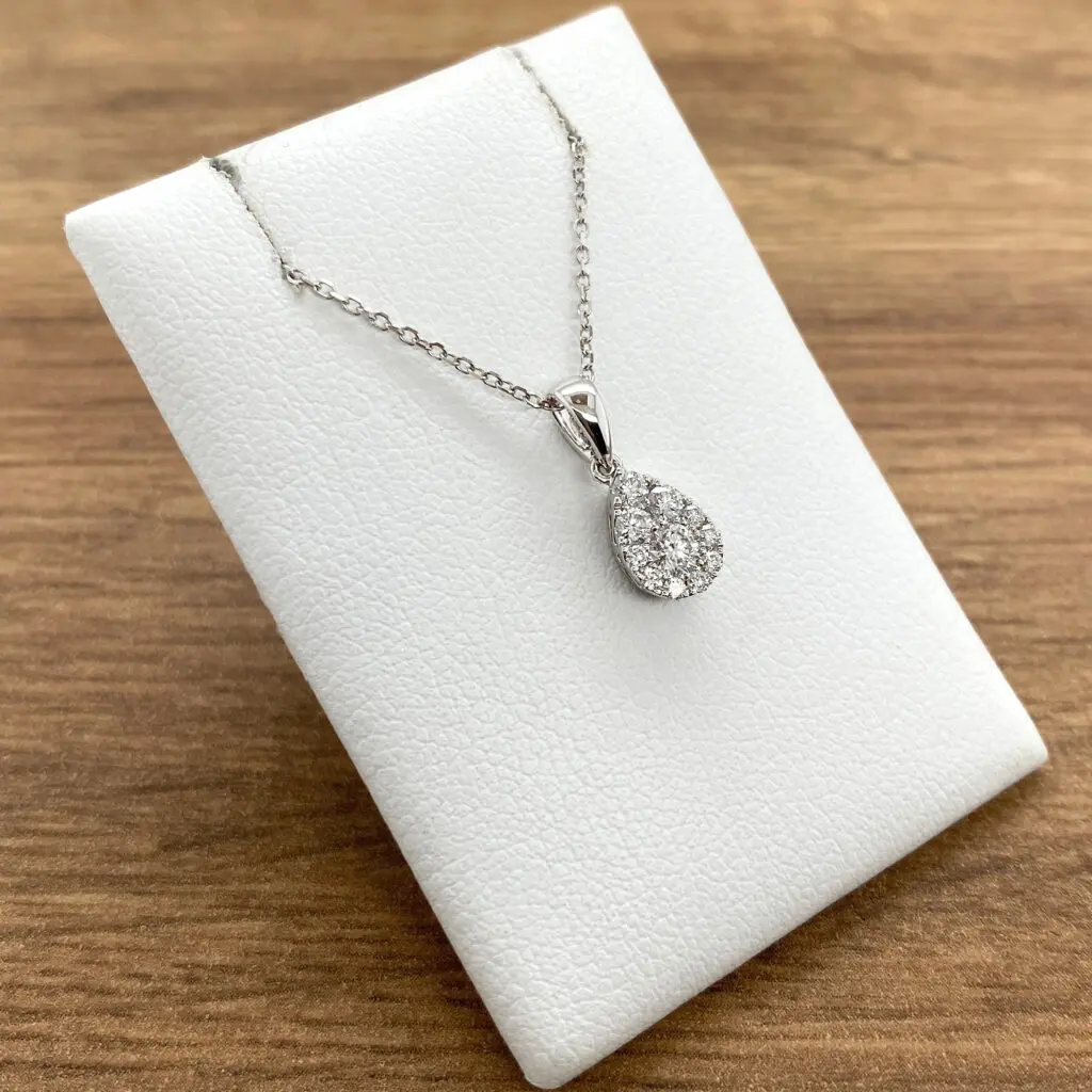 A white gold pendant with a diamond in the center.