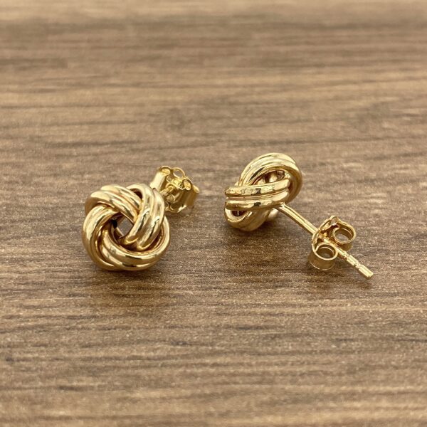 Pair of gold knot stud earrings.