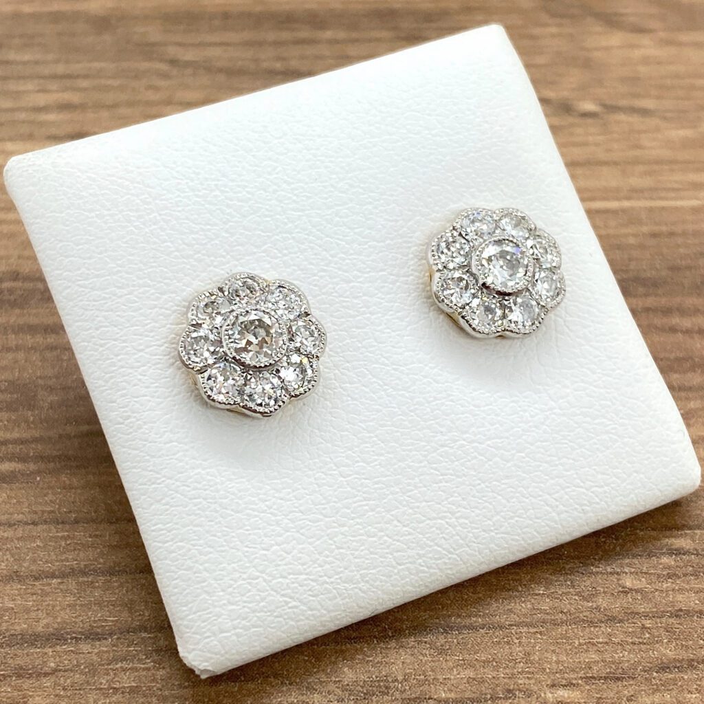 Diamond flower stud earrings on white background.