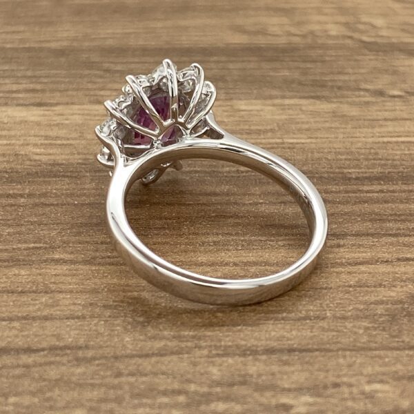 Pink gemstone ring with diamond halo.