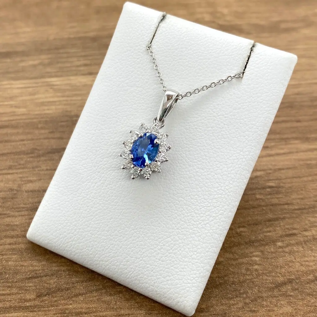 Oval sapphire pendant with diamond halo.