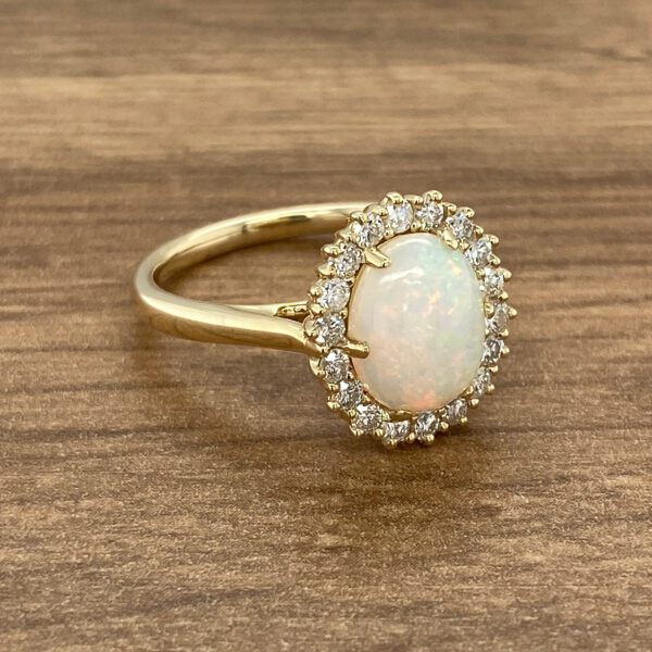 Gold ring with opal and diamond halo.