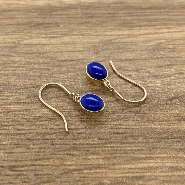 Gold earrings with blue gemstone drops.