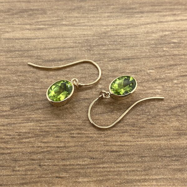 Gold earrings with green gemstone drops.