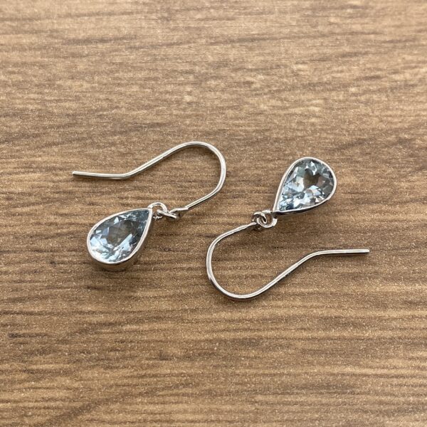 A pair of sterling silver earrings with blue topaz stones.