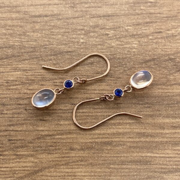 A pair of earrings with moonstones and blue sapphires.