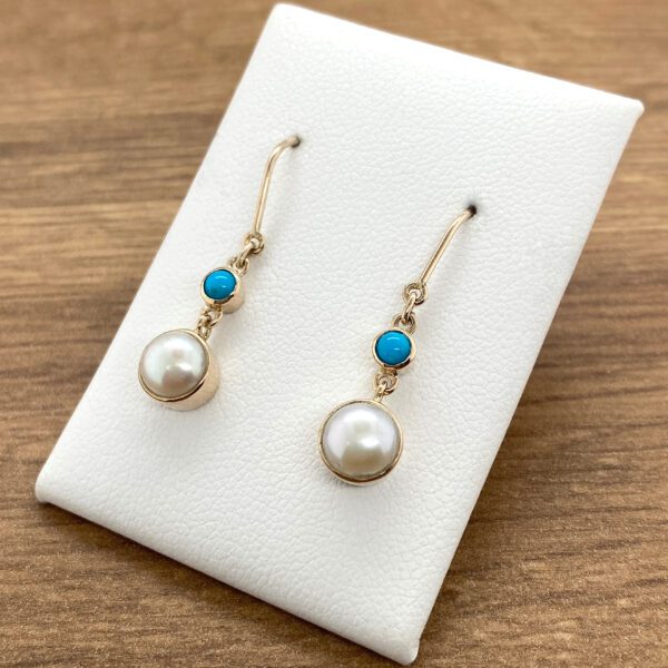 Gold pearl earrings with turquoise stones.