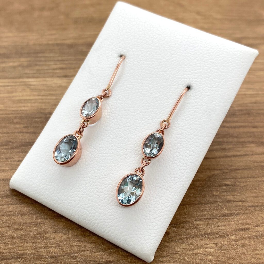 Rose gold earrings with blue gemstones.