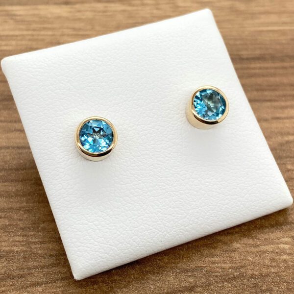 Gold earrings with blue topaz stones.