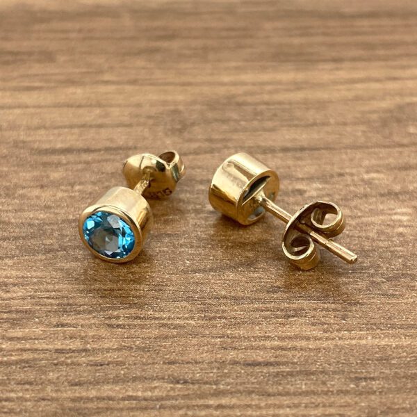 Gold earrings with blue gemstones.