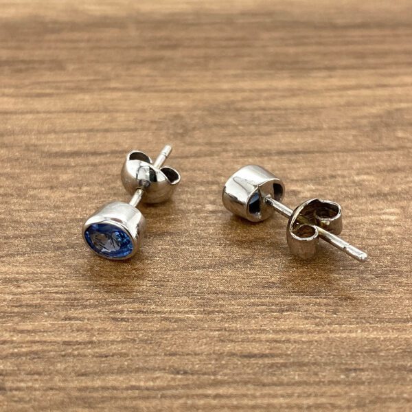 Silver stud earrings with blue gems.