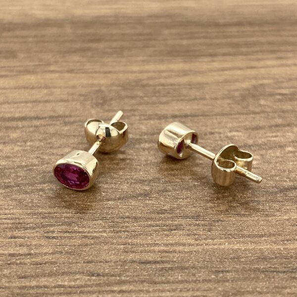 Gold earrings with red gemstones.