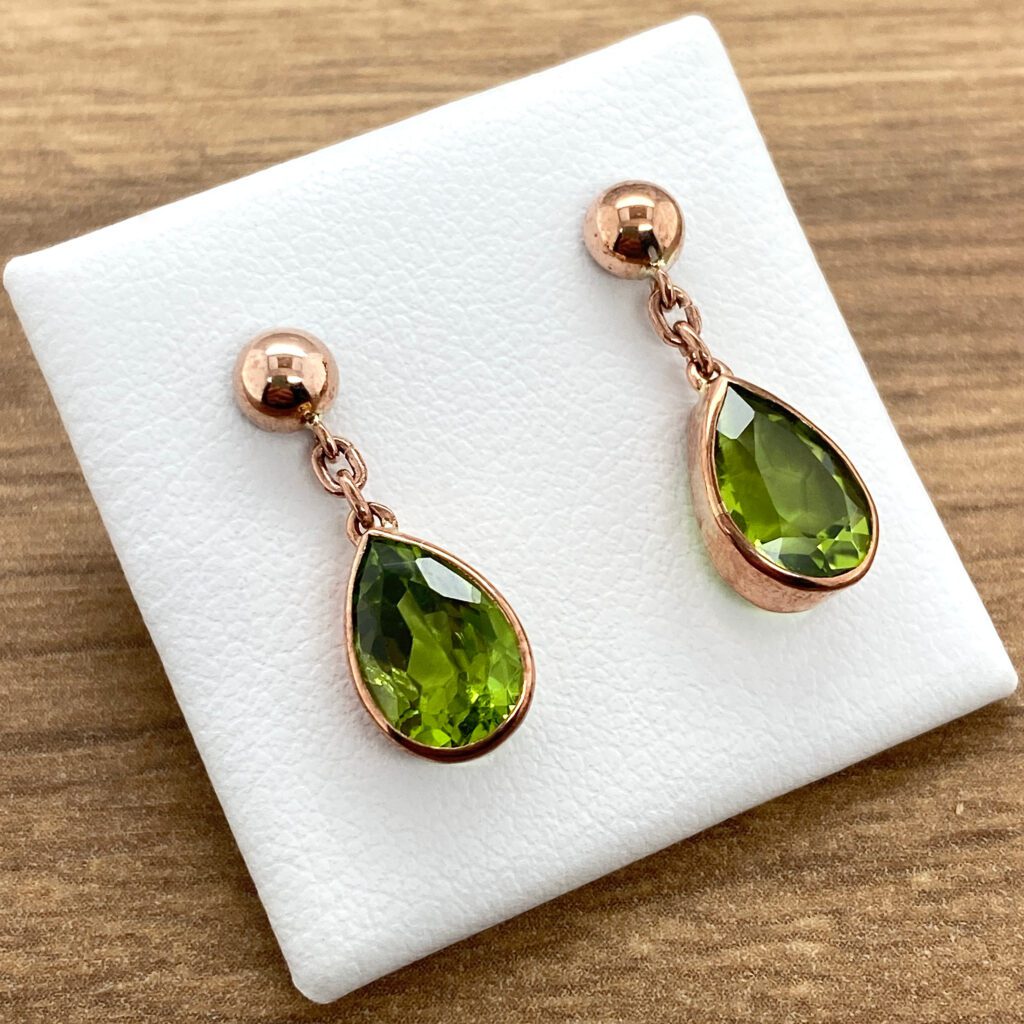 Rose gold earrings with green stones.