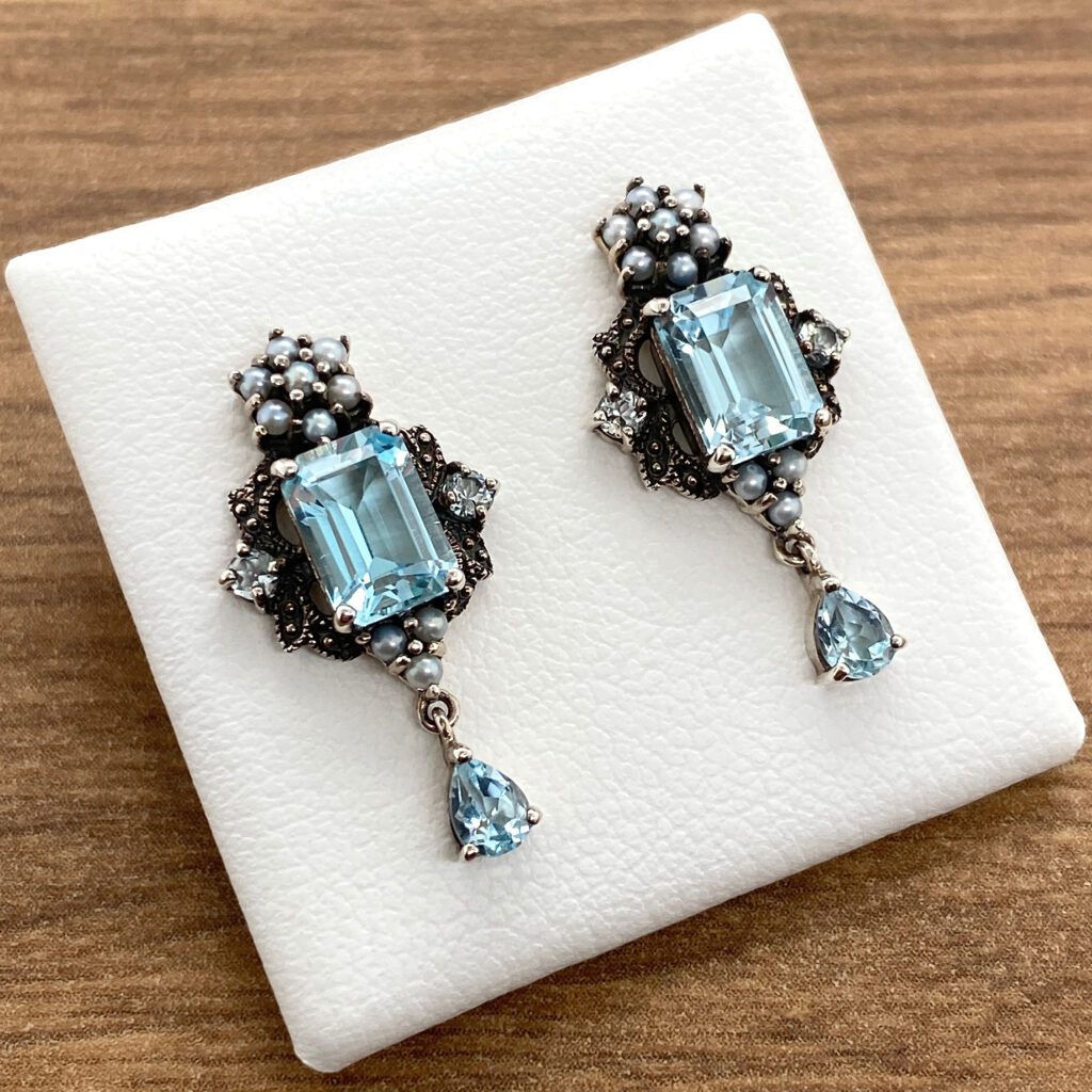 Silver earrings with blue gemstones and pearls.