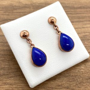 A pair of blue lapis earrings on a white plate.