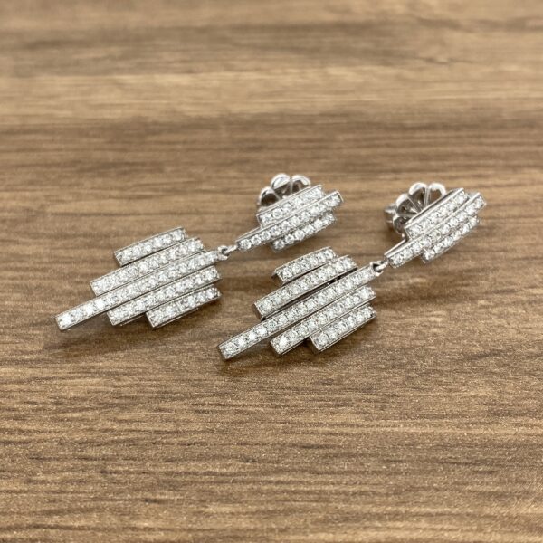 Diamond bar drop earrings on wood.