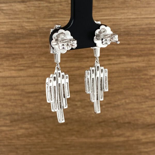Silver dangle earrings with geometric designs.