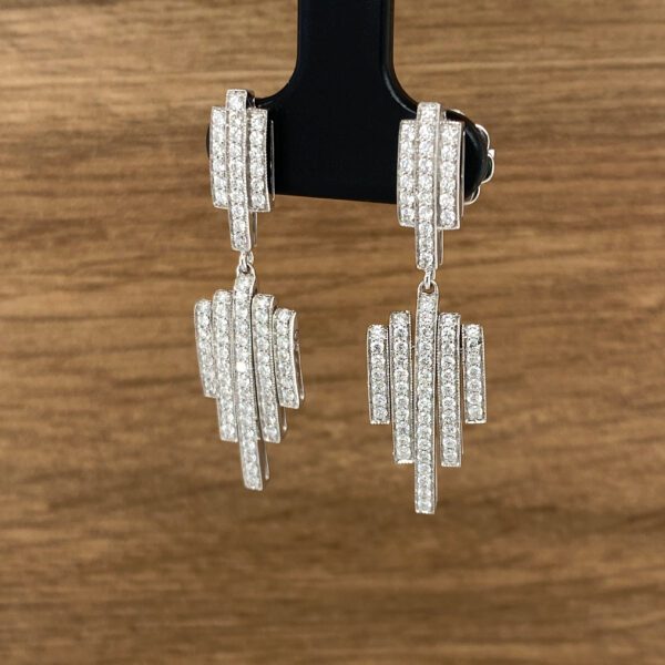 Diamond bar drop earrings on display.