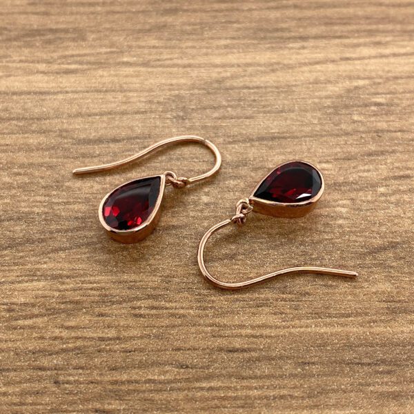 Red gemstone teardrop earrings in gold.
