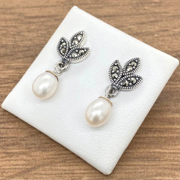 Silver pearl earrings with marcasite leaves.