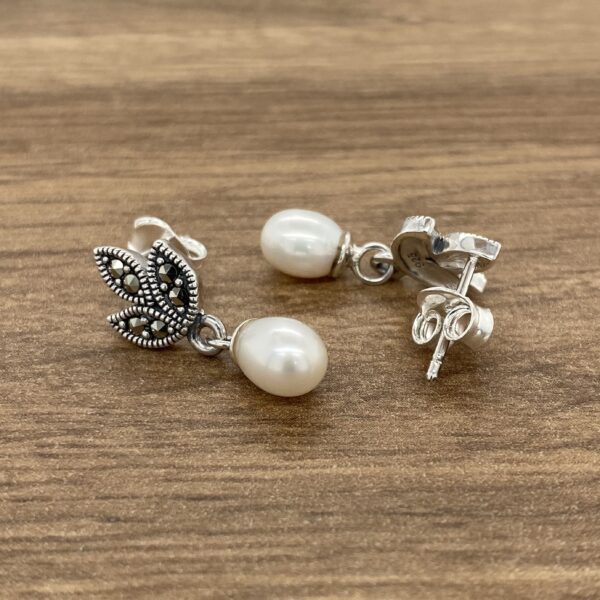 Silver pearl earrings with marcasite accents.