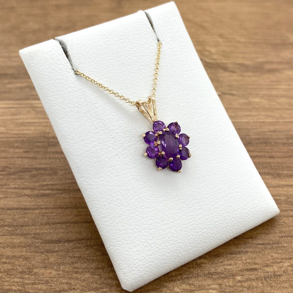 Gold chain with amethyst flower pendant.