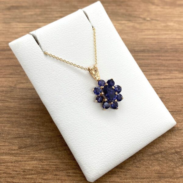 A blue sapphire pendant on a white background.