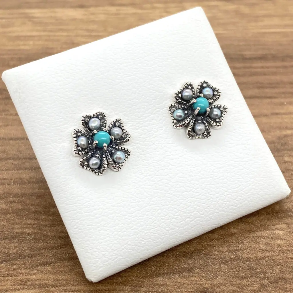 Silver flower earrings with turquoise stones.