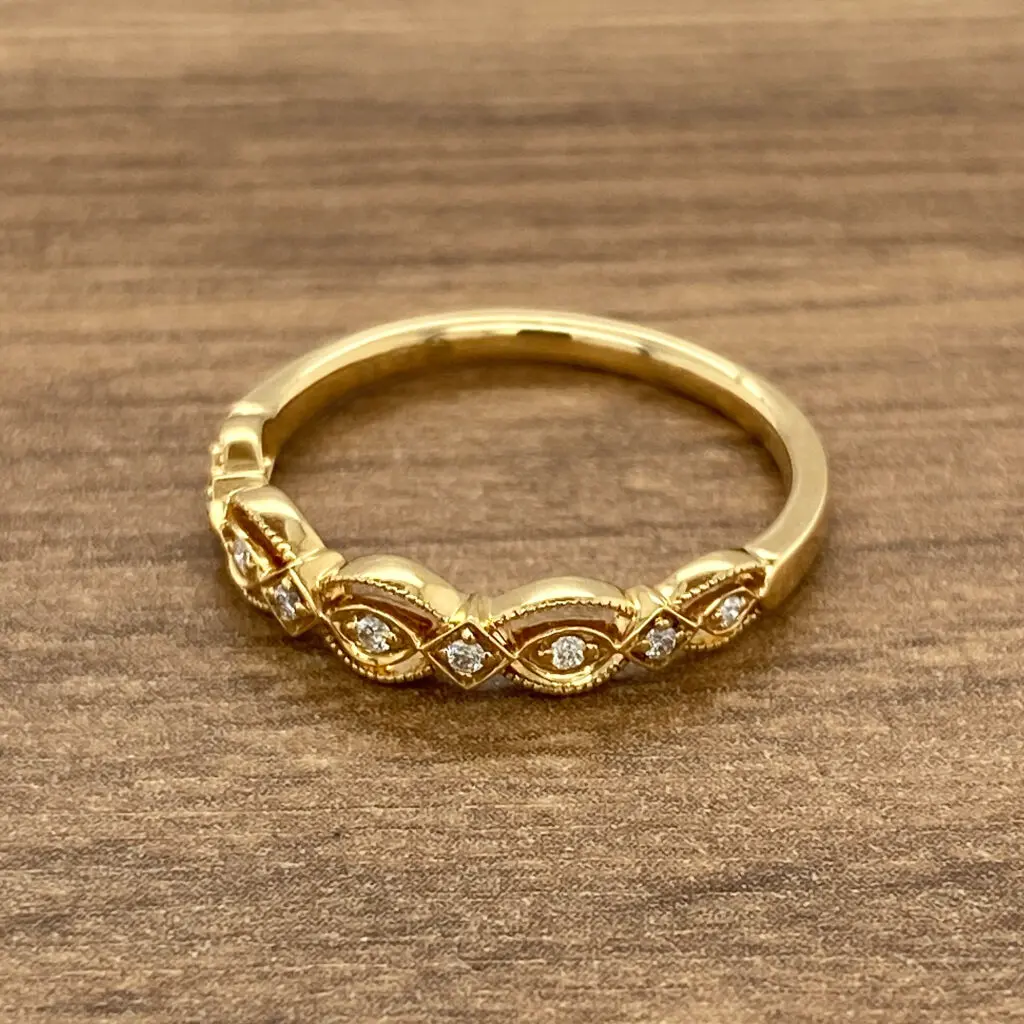 A yellow gold ring with diamonds on top.