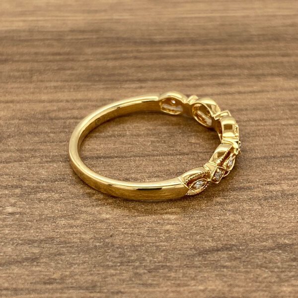 A yellow gold ring with diamonds on top.