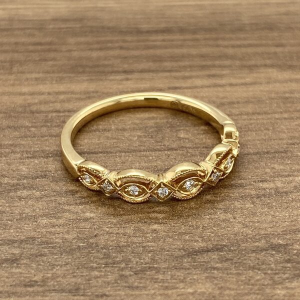 A yellow gold ring with diamonds on top.