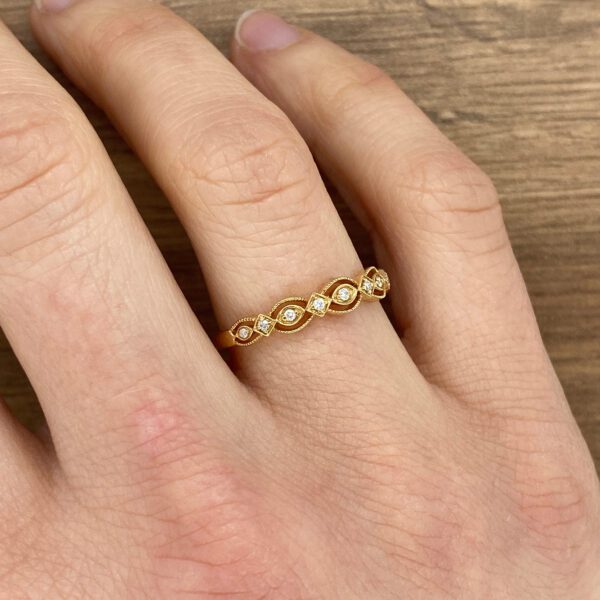 A woman's hand with a gold ring and diamonds.