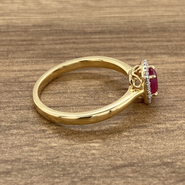 A gold ring with a ruby stone and diamonds.