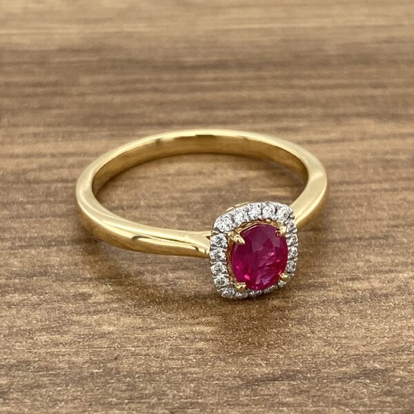 A yellow gold ring with a ruby stone and diamonds.