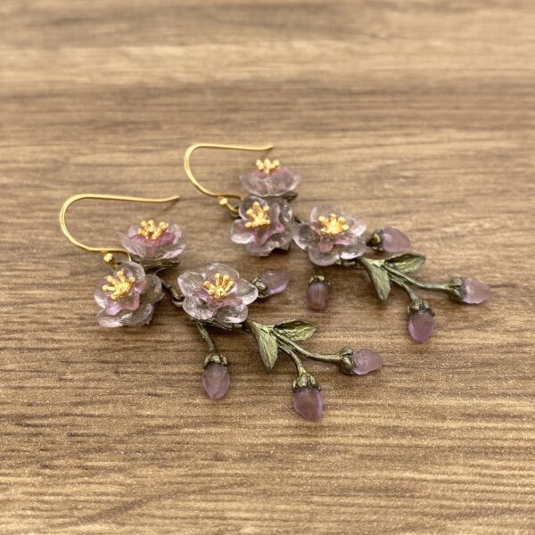 Gold earrings with pink flower charms.