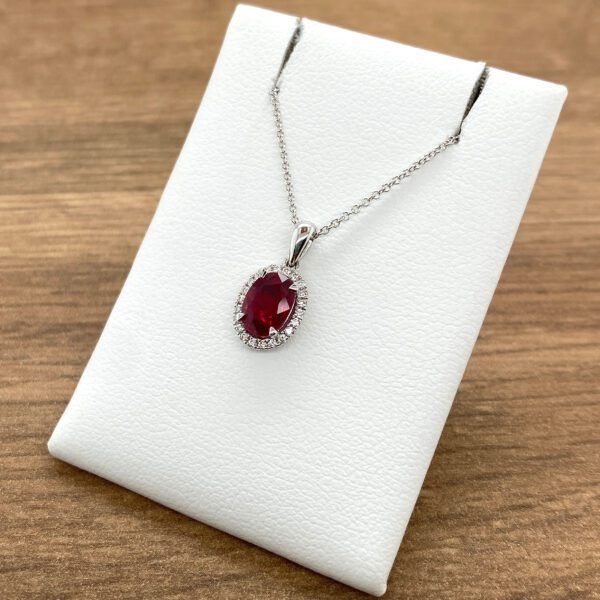 Oval ruby pendant with diamond halo