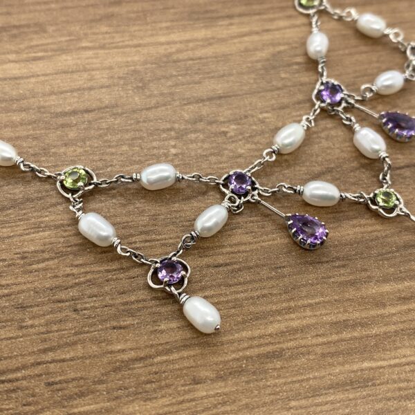 Silver necklace with pearls and gemstones.