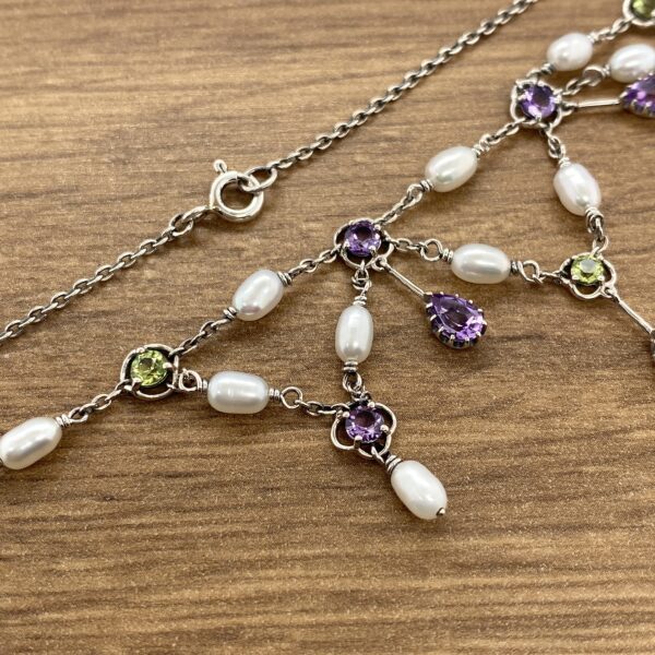 Silver necklace with pearls and gemstones.