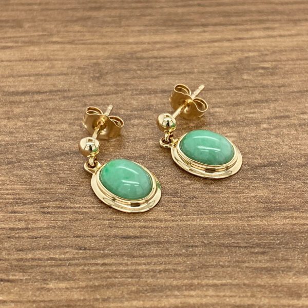 Gold earrings with green jade stones.