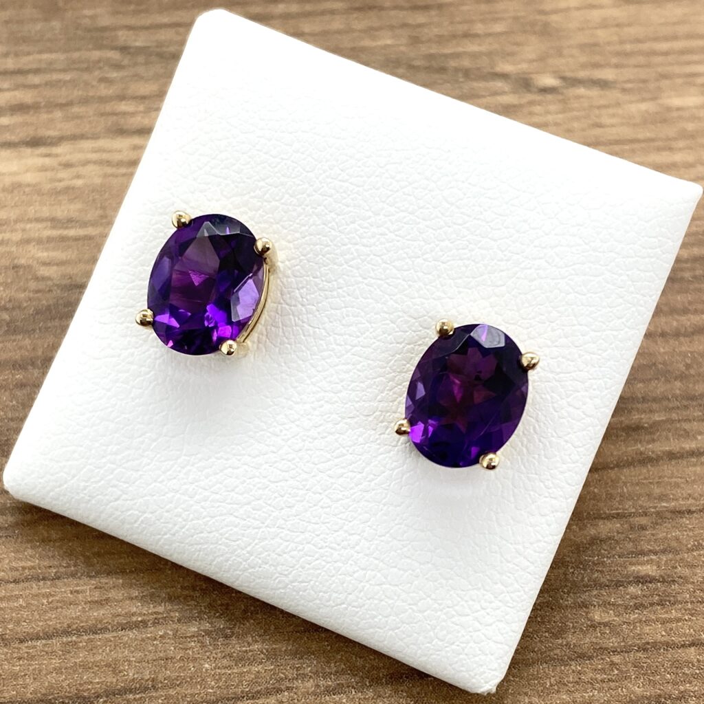 Gold earrings with oval amethyst stones.