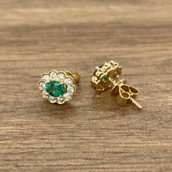 Gold earrings with emerald gemstones.